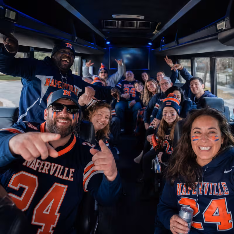 Group boarding a white charter bus for Sporting Event Transportation transportation in Naperville