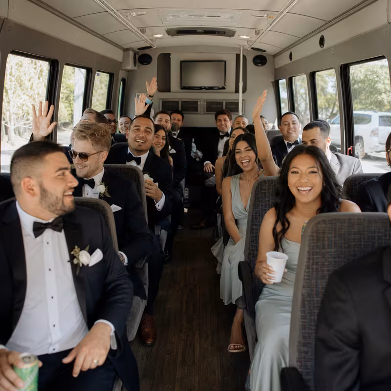 Group boarding a white charter bus for Wedding Transportation transportation in Naperville